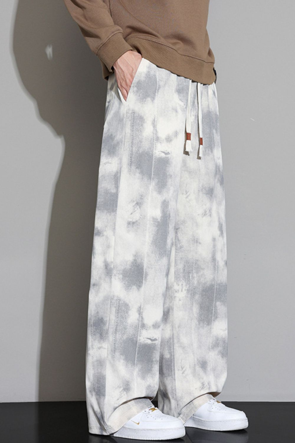 Relaxed fit sweatpants in off-white with a grey cloud pattern and drawstring waist.