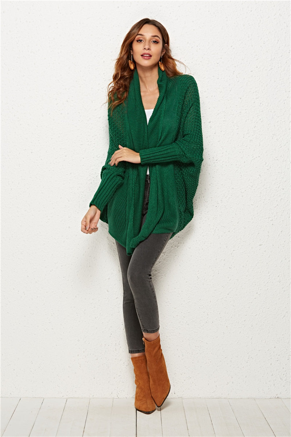Textured cocoon knit cardigan in dark green with batwing sleeves and a draped neckline.