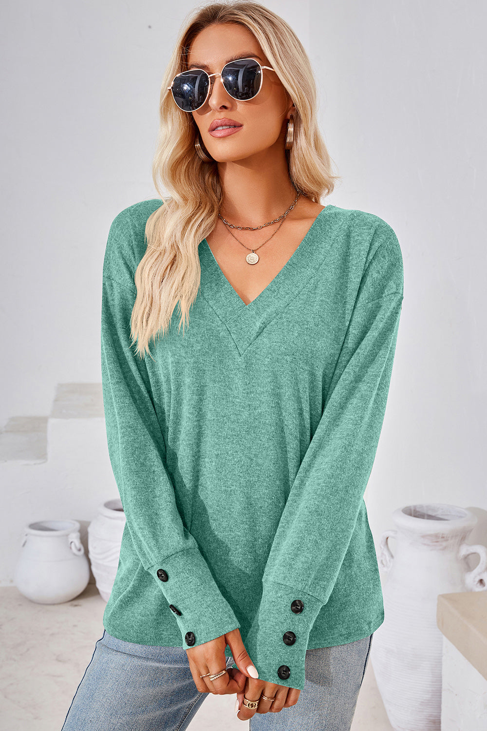 Button-cuff slouch v-neck top in light green with button details on the sleeves.