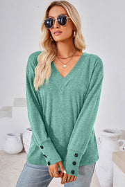 Button-cuff slouch v-neck top in light green with button details on the sleeves.