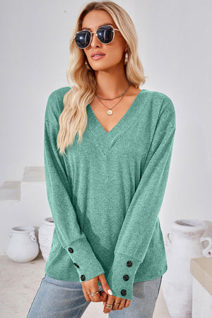 Button-cuff slouch v-neck top in light green with button details on the sleeves.
