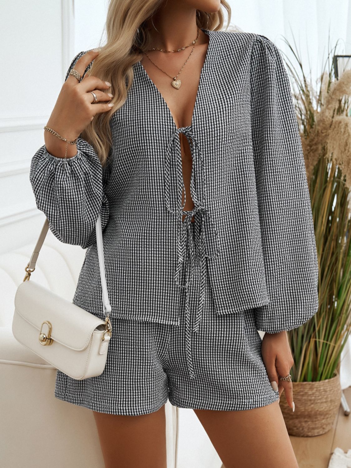 Black gingham tie-front blouse with puff sleeves and matching shorts.