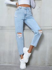 Light wash distressed boyfriend jeans with a bow detail, styled casually.