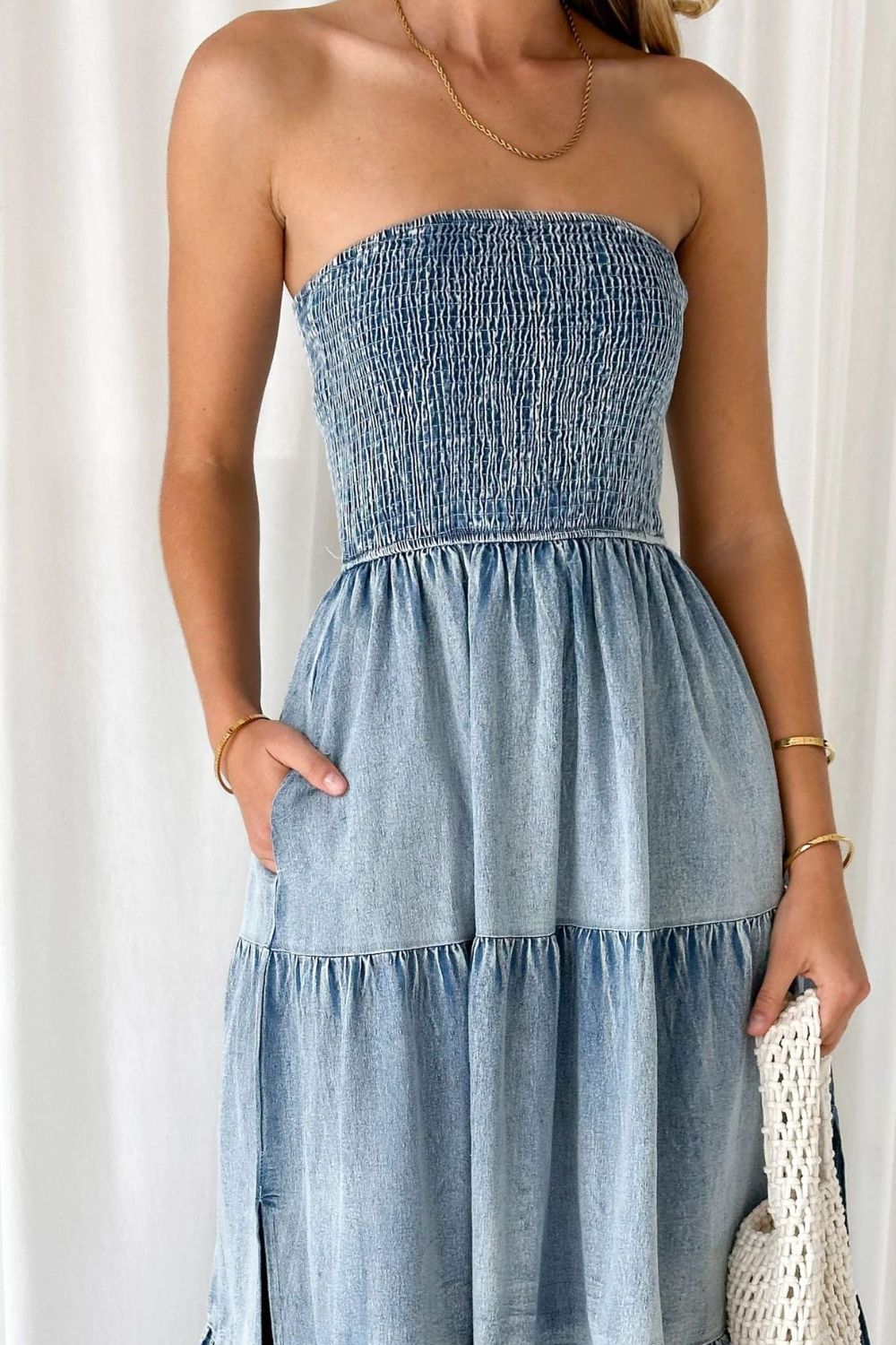 Light blue denim strapless tiered maxi dress with smocked bodice and pockets.