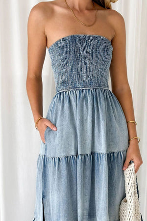 Light blue denim strapless tiered maxi dress with smocked bodice and pockets.