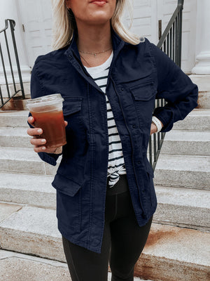 Dark Navy utility jacket with multiple pockets and a zip-up front, styled casually.