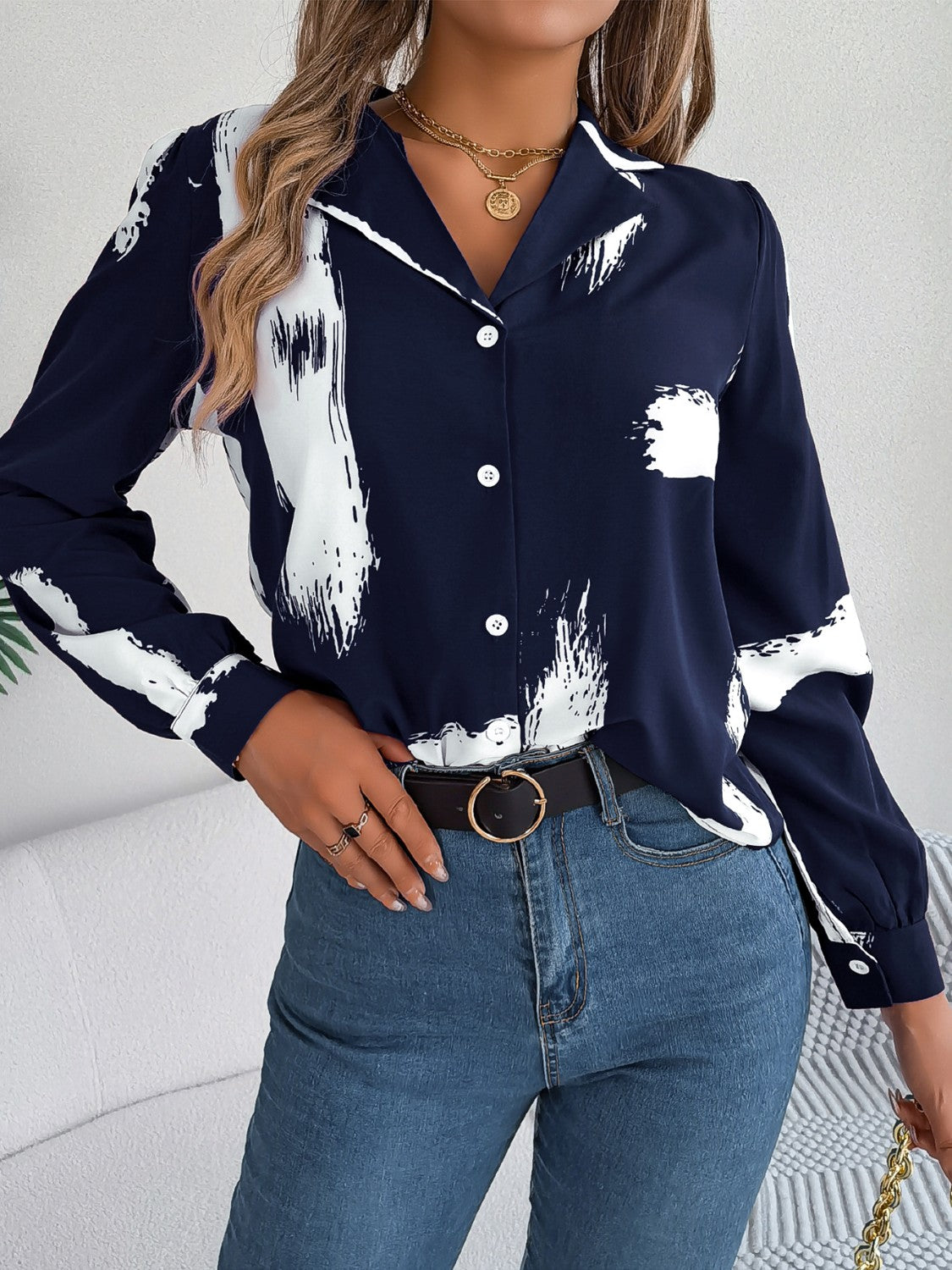 Dark blue collared blouse with white brushstroke print, button front, and long sleeves.