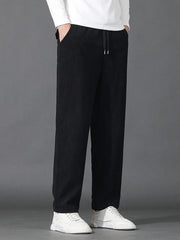 Black sweatpants with drawstring waist and pockets, styled with white sneakers.