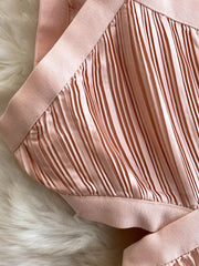 Pink pleated maxi dress with cutout detail and elastic trim.