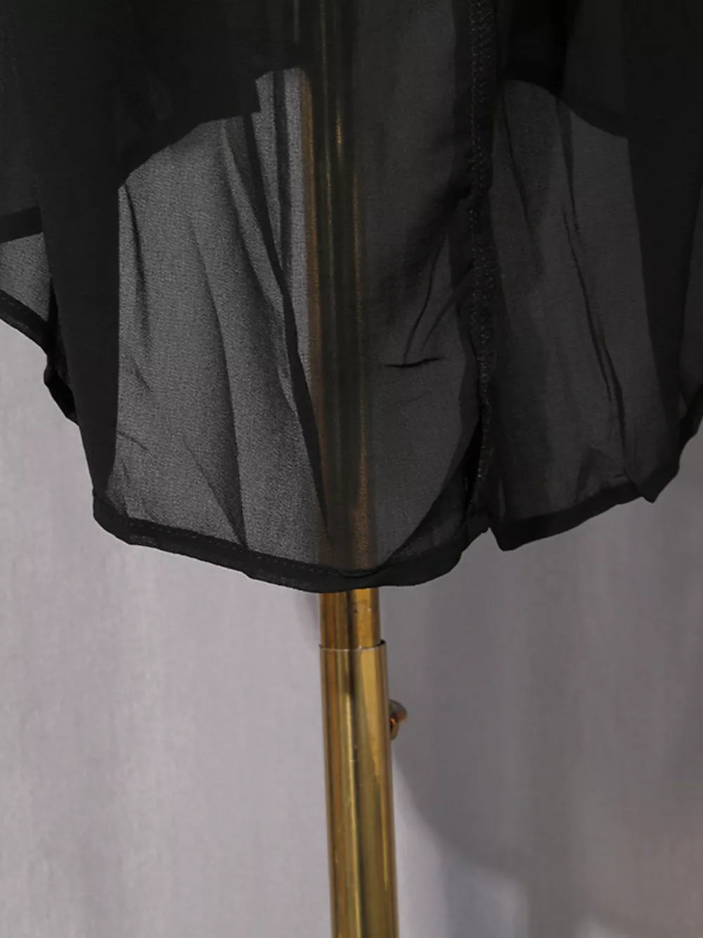 Black midi dress with sheer overlay and rhinestone embellishments.