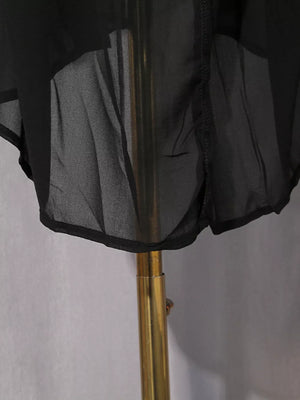 Black midi dress with sheer overlay and rhinestone embellishments.