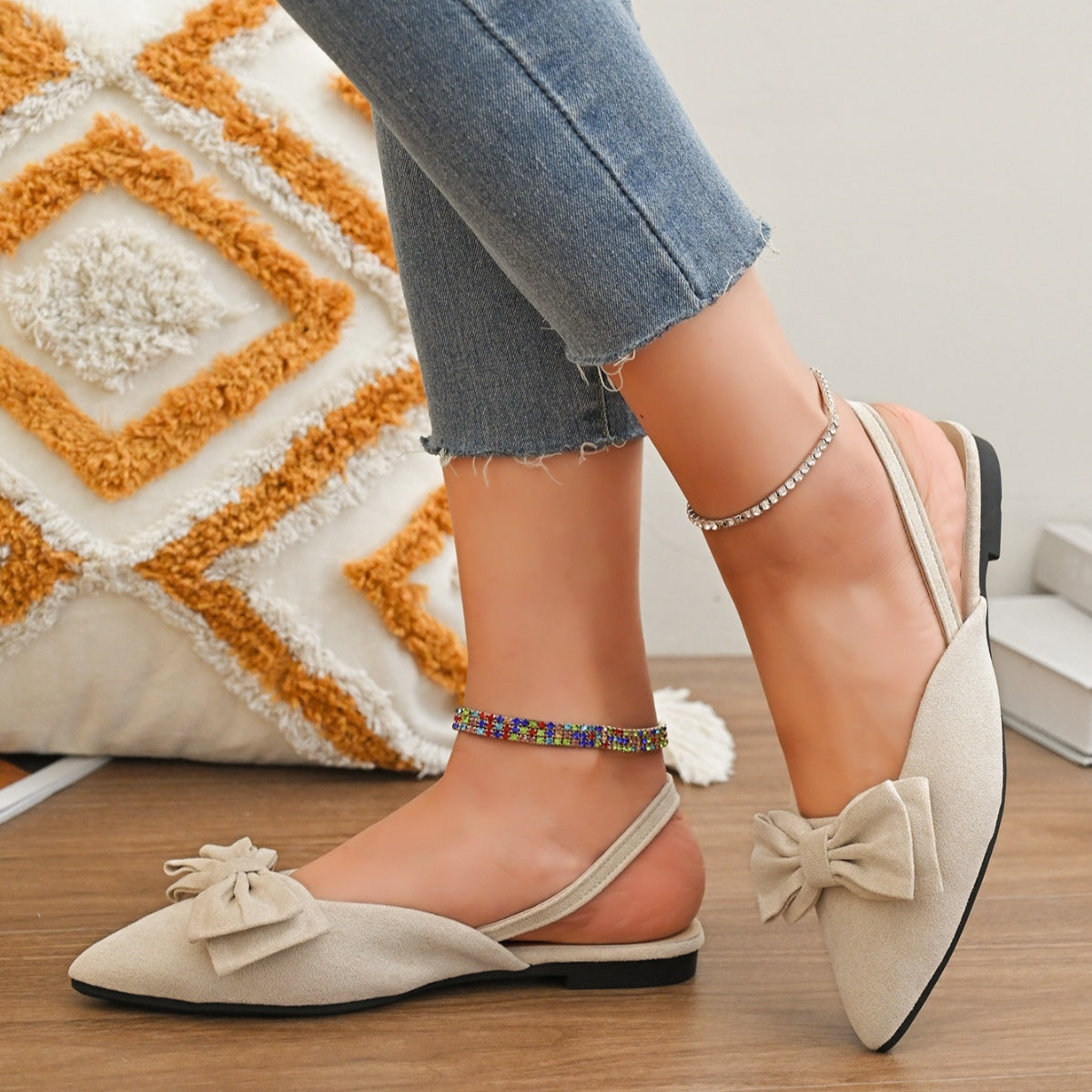 Beige slingback flats with bow detail and pointed toe, worn with jeans and anklets.