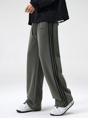 Gray wide-leg sweatpants with black side stripes and drawstring waist.