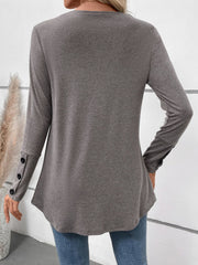 Gray button-placket tunic with subtle pleats and button cuff details.