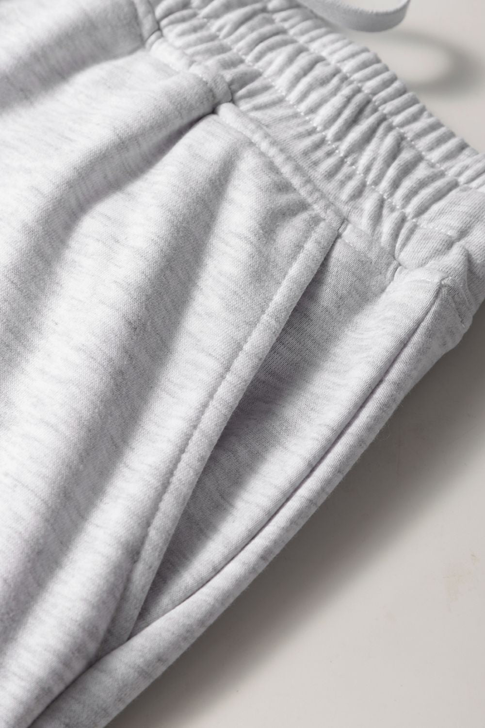 French terry drawstring skort in light gray with pockets and elastic waistband detail.