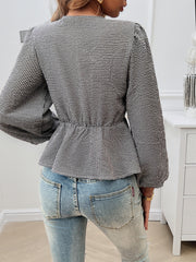 Black gingham peplum blouse with cinched waist and puff sleeves, styled with jeans.