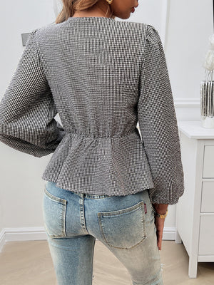 Black gingham peplum blouse with cinched waist and puff sleeves, styled with jeans.