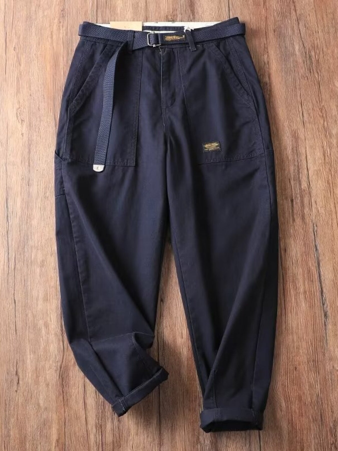 Men's dark navy loose fit cargo pants with belt and pockets.
