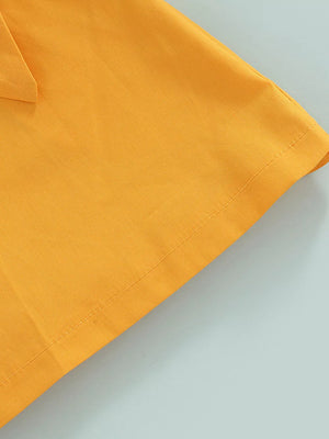 Yellow knit baby outfit detail showing bow and stitching.