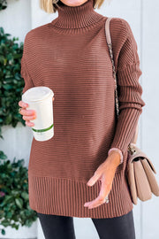 Brick red ribbed turtleneck sweater with extended hem and textured sleeves.