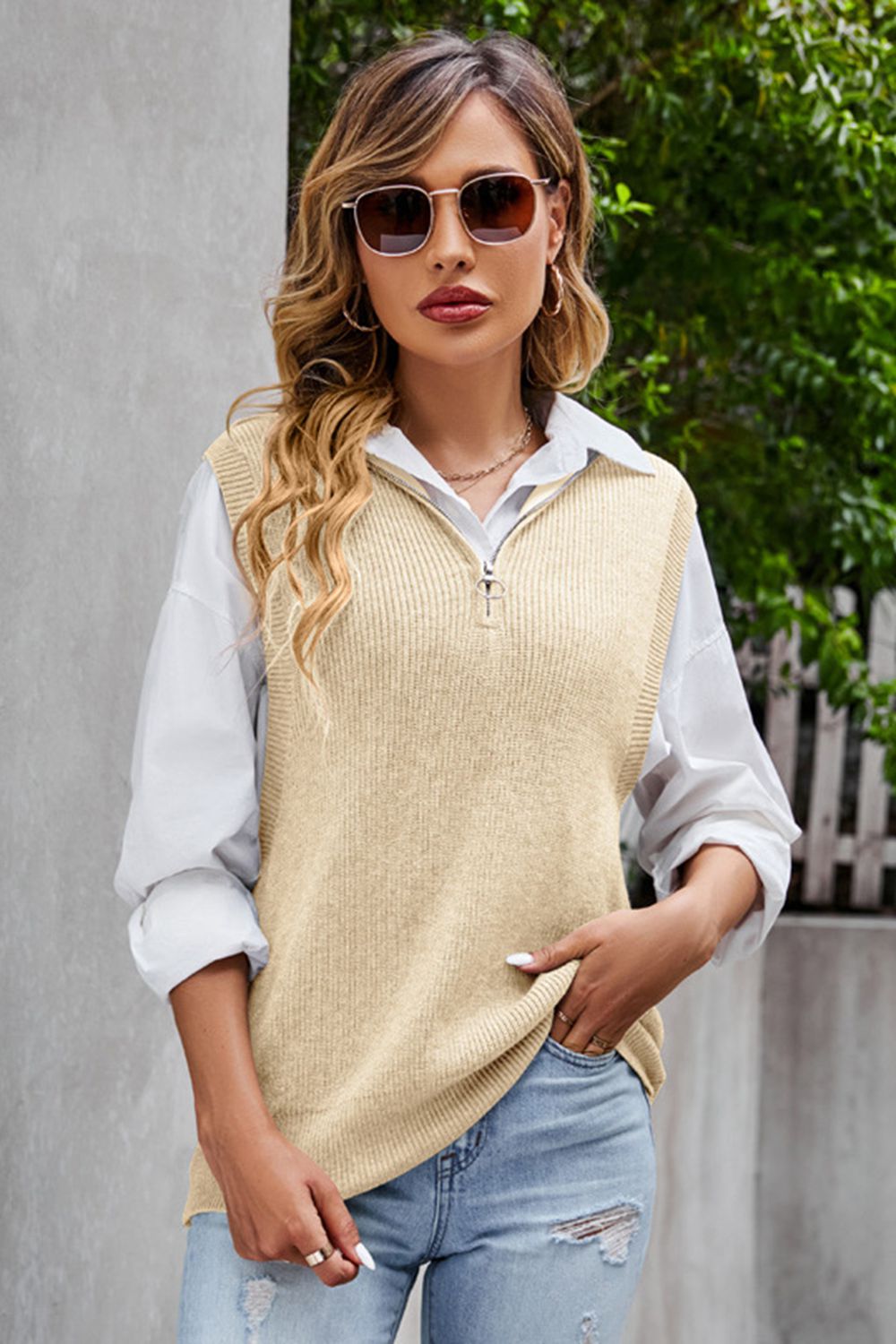 Tan ribbed knit vest with quarter zip and collar, worn over a white shirt.