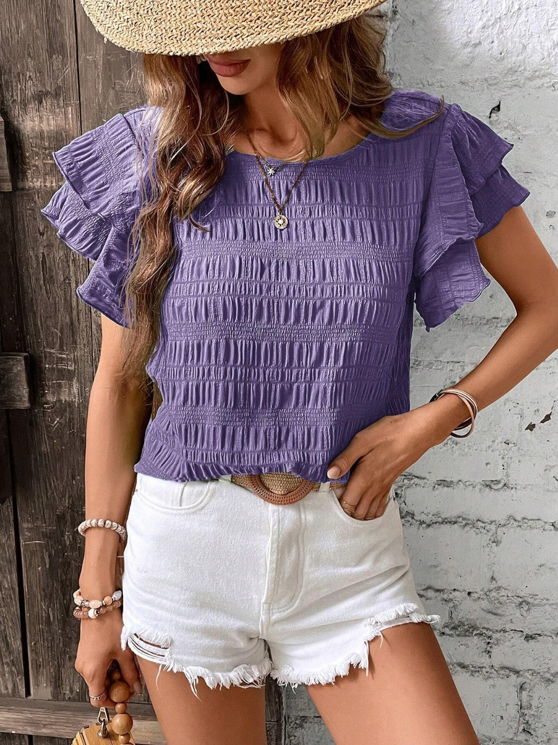 Purple smocked blouse with ruffle sleeves and textured fabric.