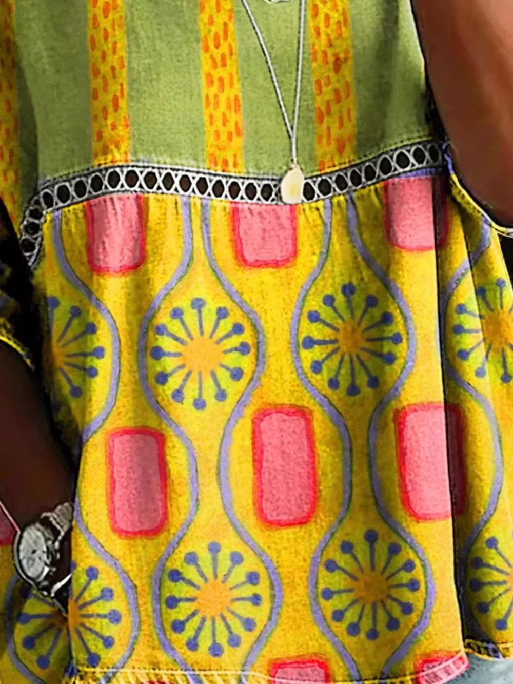 Bohemian maternity t-shirt in yellow with floral and geometric print, openwork detail, and striped green yoke.