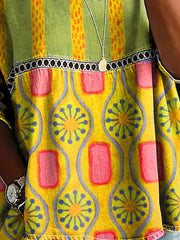 Bohemian maternity t-shirt in yellow with floral and geometric print, openwork detail, and striped green yoke.