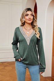 Green relaxed knit sweater with lace-trimmed V-neck and long sleeves.