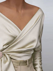 Cream draped satin blouse with brooch detail and V-neckline
