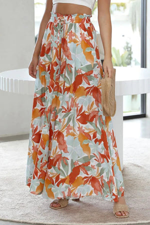 Botanical print palazzo trousers with a drawstring waist and wide legs in orange-red, aqua, and green.