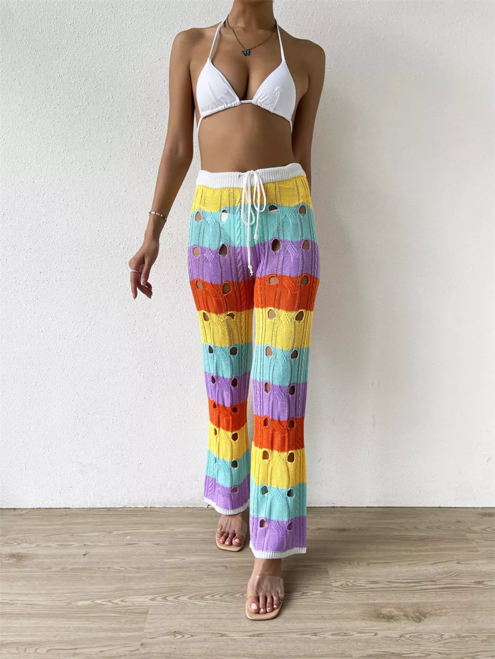 Vibrant crochet knit maternity pants with rainbow stripes and cutout details.