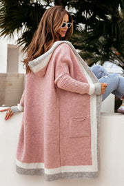 Color-blocked hooded knit maxi cardigan in dusty pink with gray and white trim, featuring ribbed sleeves and a pocket.