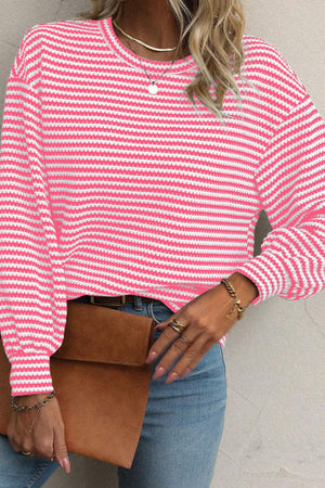 Pink and white striped textured knit top with balloon sleeves.