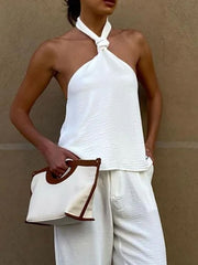 White twisted backless halter cami with textured fabric and a knotted neckline.