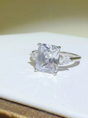 Silver ring with emerald cut center stone and pear accent stones