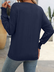 Dark Navy textured blouson top with smocked cuffs and long sleeves.