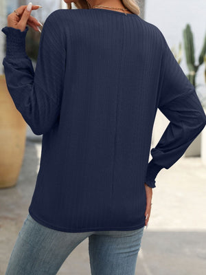 Dark Navy textured blouson top with smocked cuffs and long sleeves.