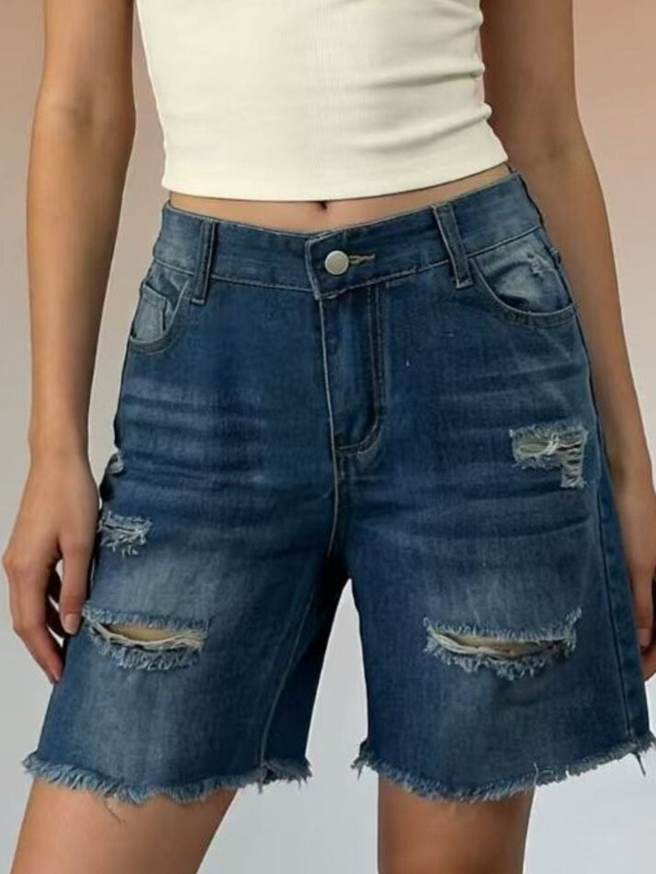 Distressed dark blue denim shorts with frayed hem and ripped details.