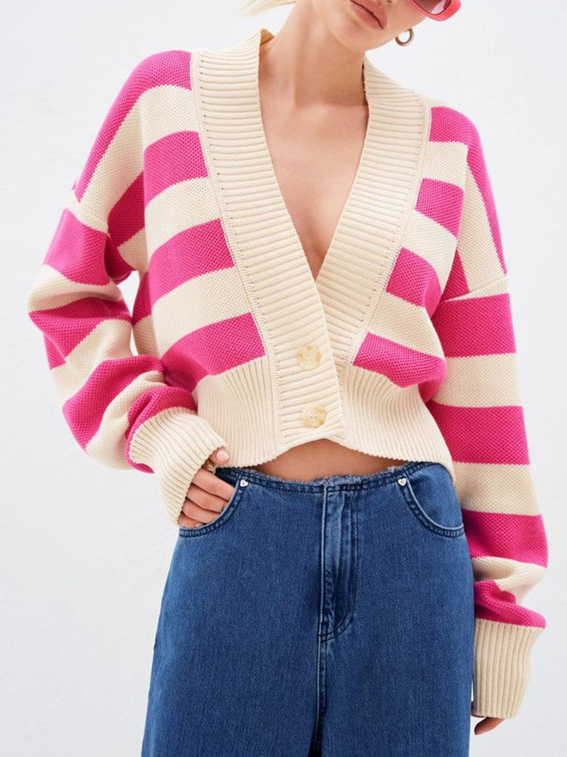 Cropped pink and cream striped knit cardigan with button front and V-neck.