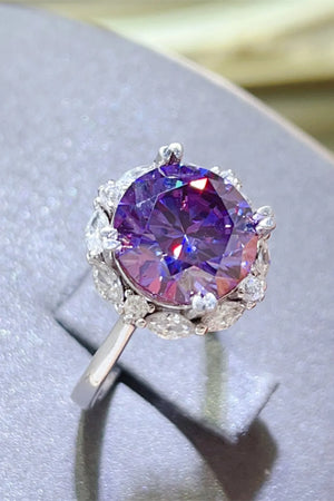 Amethyst halo cocktail ring in silver with a large round purple amethyst and surrounding white stones.