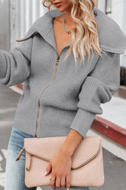 Gray ribbed knit cardigan with shawl collar and zip front, styled with jeans and a clutch.