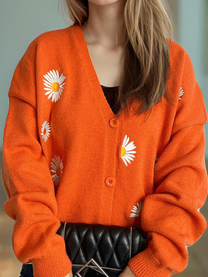 Orange acrylic oversized knit cardigan with embroidered daisies and buttons
