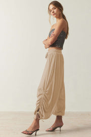 Tan gathered ankle-tie balloon trousers with a drawstring waist and ruched detail.