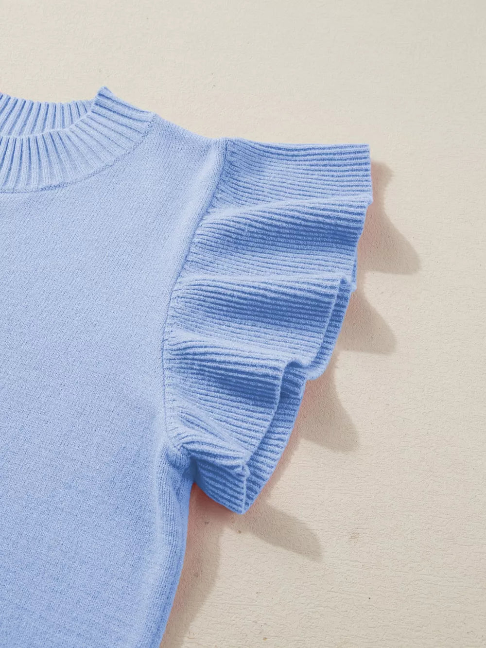 Light blue ribbed knit top with round neck and ruffled short sleeves.