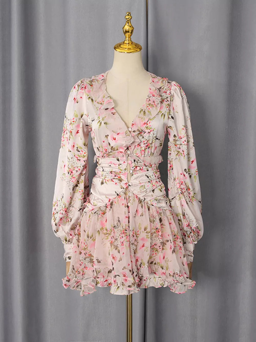 Charming ruffled floral mini dress with V-neck, long sleeves, and button detail.