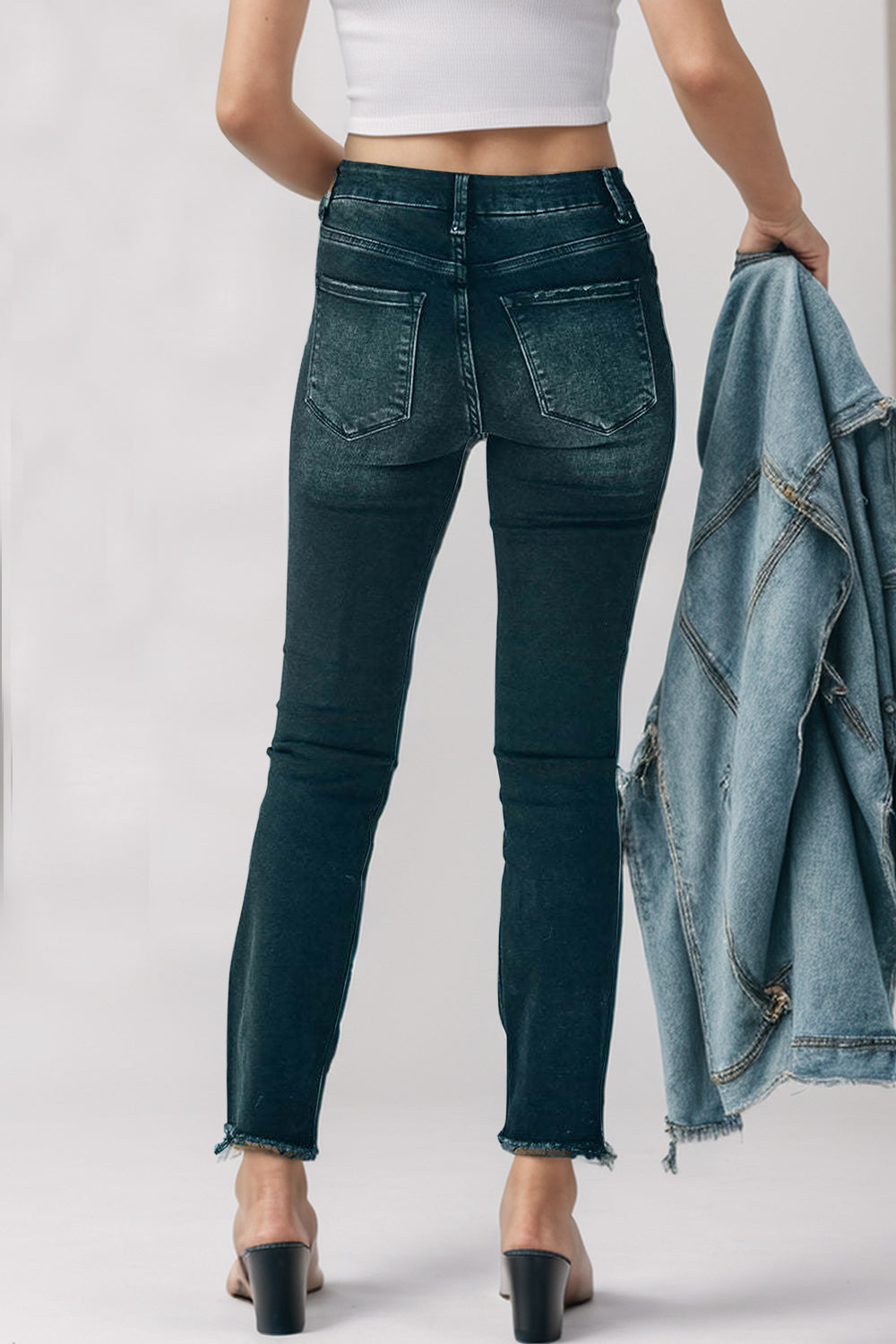 Black high-rise jeans with faded wash and raw hem detail.