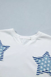 White cotton tee with notched neckline and blue star applique details.