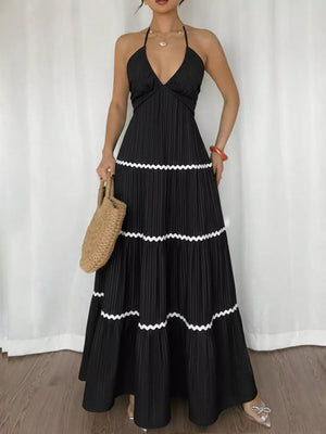 Black ruched halter maxi dress with tiered skirt and white trim.