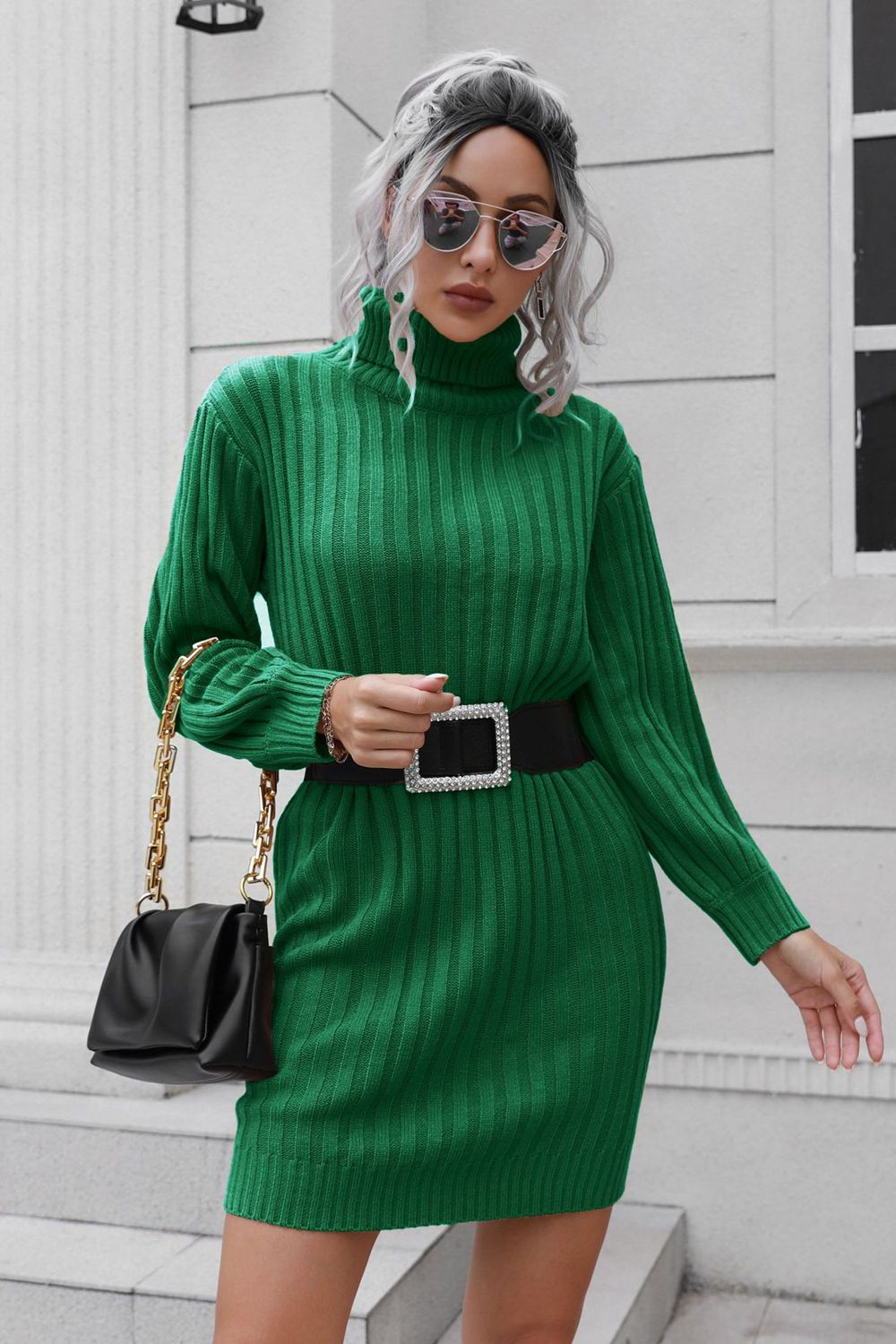 Green ribbed turtleneck mini dress with long sleeves and a black jeweled belt.